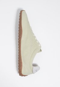 Beežid seemisnahast vabaajajalatsid pruunide kummist tallaga, millel on ümarad haardepinnad, valged paelad ja valge kannatäpp mullatud kaubamärgiga.