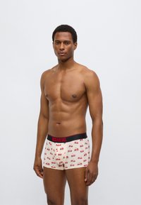 Ανδρικά μπόξερ με ανοιχτό μπεζ φόντο και σχέδιο με κεράσια. Διαθέτουν μαύρη μέση με κόκκινο λογότυπο «DIESEL». Υλικό από βαμβάκι, εφαρμοστή σχεδίαση.