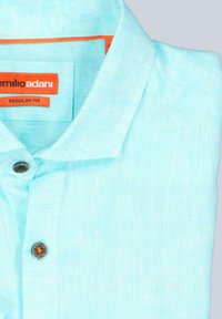 Hellblaues Leinenhemd mit Kragen, ausgestattet mit einem einzelnen Knopfverschluss und einem orangefarbenen Etikett mit der Aufschrift "Emilio Adani, Regular Fit."