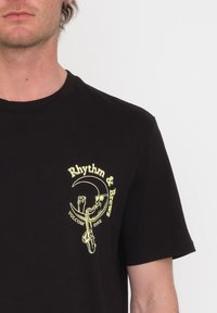 Zwarte katoenen t-shirt met een gele grafische ontwerp met de tekst "Rhythm & Brews" en afbeeldingen van handen die glazen vasthouden en een ketting.