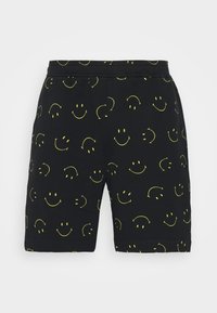 Shorts noirs en coton, ornés d'un motif de visages souriants jaunes, avec une taille élastique et une coupe décontractée.