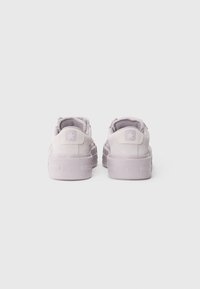 Purple suede low-top sneakers with a textured finish, featuring a rubber sole, rounded toe, and star logo on the heel.