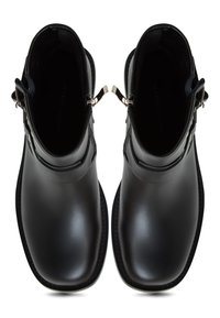 Botine negre din piele pentru gleznă cu o textură netedă, având o cataramă strălucitoare din argint și cusături contrastante pe margini.