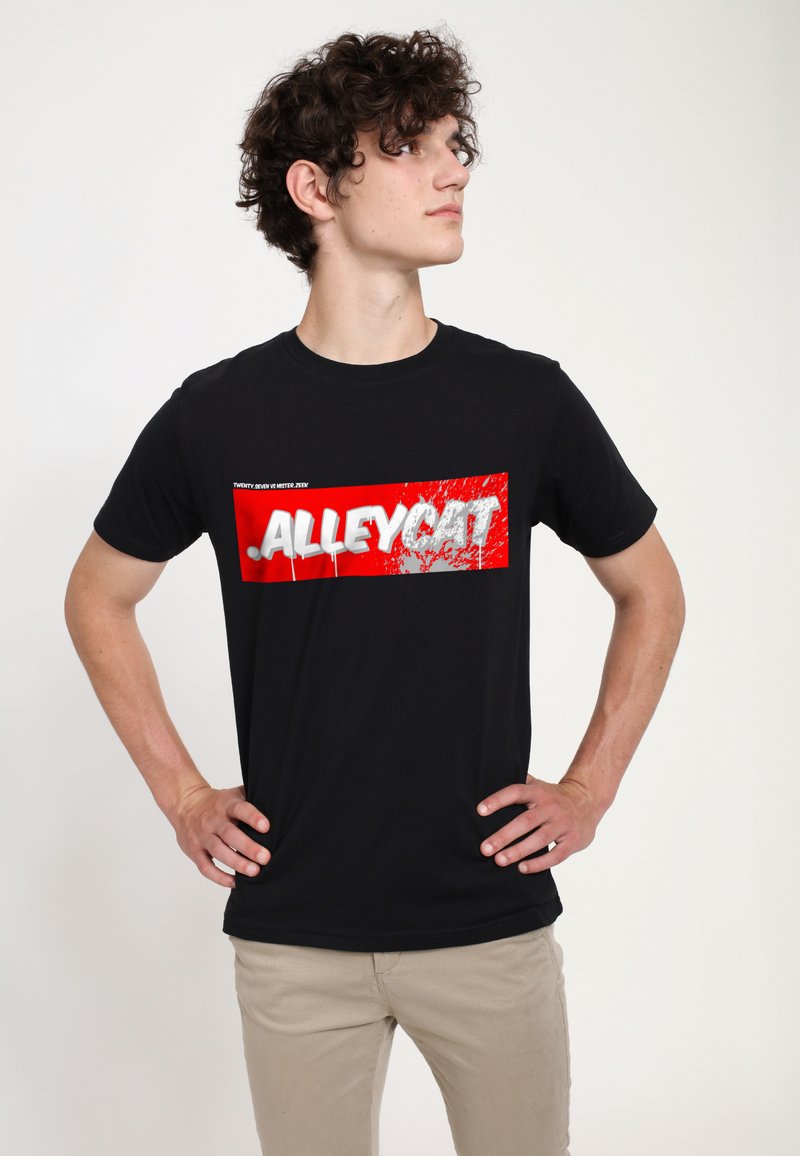 Černé bavlněné tričko s výraznou červenou obdélníkovou grafikou, na které je napsáno "ALLEYCAT" bílým písmem, na jednoduchém pozadí.