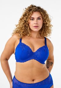 Blue bra with floral embroidery, featuring adjustable straps, lace trim, and a smooth cup design. Complementary matching briefs are visible.