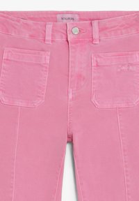 Pantaloni di denim rosa con tasche a toppa frontali, chiusura con bottone argento, passanti per cintura e etichetta del marchio Scalpers su vita e tasca.