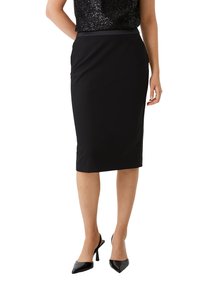 Schwarzer Bleistiftrock aus elastischem Gewebe, knielang mit glatter Textur und seitlichen Schlitzen, kombiniert mit schwarzen High Heels.