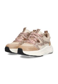Des baskets avec un schéma de couleurs beige et or, présentant une tige texturée, des accents brillants et une semelle blanche épaisse. Les lacets sont dans des teintes assorties.