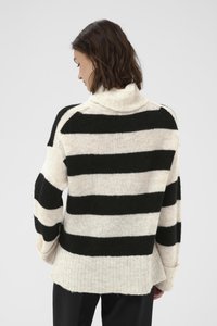 Pulover în dungi, cu alternanțe de culori negre și crem, guler înalt și o croială lejeră, cu manșete și tiv ribbate. Textură moale.