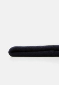 Material tricotat de culoare bleumarin, rulat, având o suprafață texturată și margini netede. Prezintă un material moale, cu o culoare uniformă.