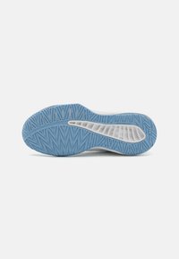 Semelle de chaussure avec un fond en caoutchouc bleu présentant un motif en chevrons texturé. Semelle intermédiaire blanche avec des détails en relief pour une meilleure adhérence.