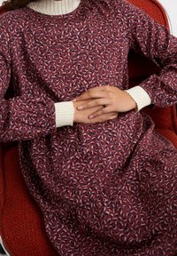 Robe bordeaux avec un motif léopard dispersé, dotée d'un col blanc côtelé et de manches bouffantes, fabriquée en tissu doux.