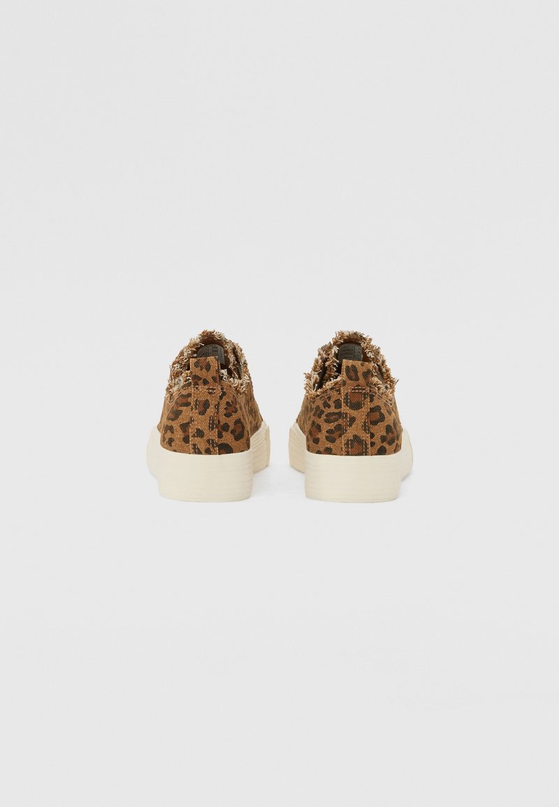 Baskets en toile à imprimé léopard avec des détails effilochés, semelles en caoutchouc beige et finition texturée. La vue montre l'arrière des chaussures.