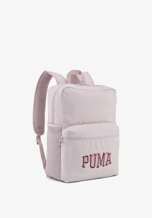 Jasnoróżowy plecak Puma z wyściełanymi paskami na ramiona, przednią kieszenią na zamek, bocznymi kieszeniami z siatki oraz logo Puma na przedniej kieszeni.