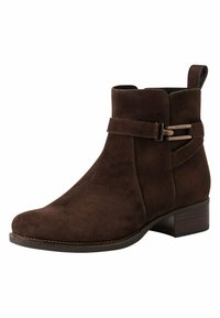 Botte chelsea marron en suède avec un bout arrondi et un petit talon. Comprend une sangle latérale avec une boucle en métal et une languette pour un enfilage facile.