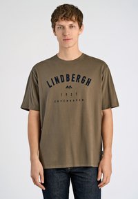 Camiseta de algodón verde oliva con mangas cortas y cuello redondo, con texto impreso en marino "LINDBERGH 1927 COPENHAGEN" en la parte frontal.