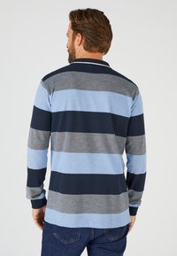 Polo a maniche lunghe con strisce blu, grigie e blu navy. Presenta un colletto classico, texture a maglia e polsini a costine.