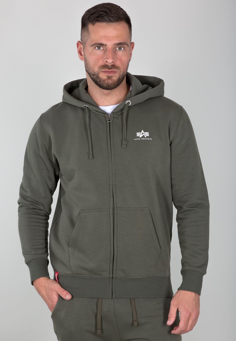 Haut à capuche zippé en vert olive fabriqué en mélange de coton. Comprend des poches kangourou, une capuche ajustable, des poignets côtelés et un petit logo sur la poitrine.