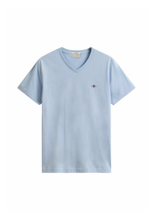 T-shirt bleu clair à col en V et manches courtes avec un petit logo brodé sur le côté gauche de la poitrine et une étiquette de marque à l'intérieur du col.