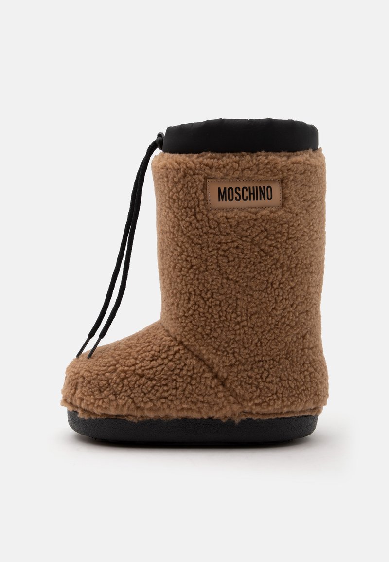 Καφέ χειμερινή μπότα με υφή από fleece, μαύρη σόλα, μαύρο επάνω περίγραμμα, κορδόνι και το λογότυπο Moschino στο πλάι.