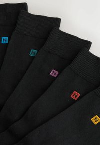 Sorte sokker med ribbede manchetter, der viser små farvede firkantede logo accenter i blå, lilla, rød og gul på hvert par.