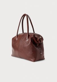 Brązowa skórzana torebka o gładkiej fakturze, z podwójnymi uchwytami, zamkiem błyskawicznym u góry oraz ozdobnymi srebrnymi detalami. Pojemna i starannie wykonana.