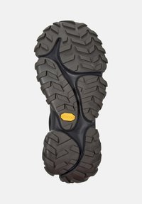 Black shoe sole with deep, rugged tread patterns, featuring a yellow Vibram logo, designed for traction and durability. Size 42.