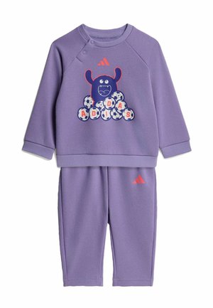 Fioletowy zestaw dla malucha składający się z bluzy i spodni z zabawną grafiką potwora oraz piłkami nożnymi układającymi napis "ADIDAS", z czerwonym logo Adidas na obu elementach.
