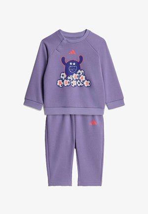 Conjunto morado de sudadera y pantalones para niños pequeños con gráfico divertido de monstruo y balones de fútbol que forman "ADIDAS", con logotipo rojo de Adidas en ambas prendas.
