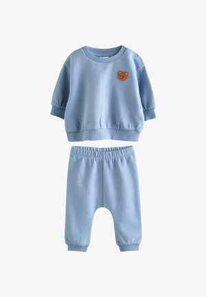 Lichtblauw sweatshirt en broek set gemaakt van zachte stof. Het sweatshirt heeft een ronde hals met een berenpatch; de broek heeft een elastische tailleband.
