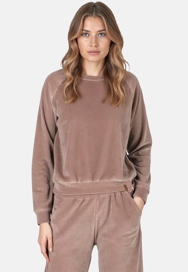 Felpa in velour marrone con maniche lunghe, scollo rotondo e polsini a costine. Texture morbida e vestibilità rilassata, abbinata a pantaloni coordinati.