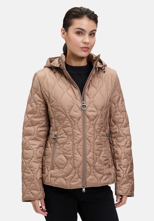 Veste matelassée marron clair avec capuche, présentant un zip à l'avant et des poches latérales, un motif texturé et des accents en métal argenté.