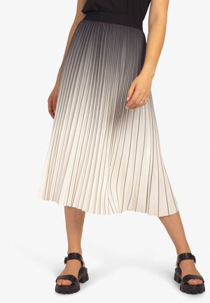 Faltender Midirock in einem Farbverlauf von Weiß nach Grau, mit vertikalen schwarzen Streifen. Glattes Material und breiter Bund, kombiniert mit klobigen schwarzen Sandalen.