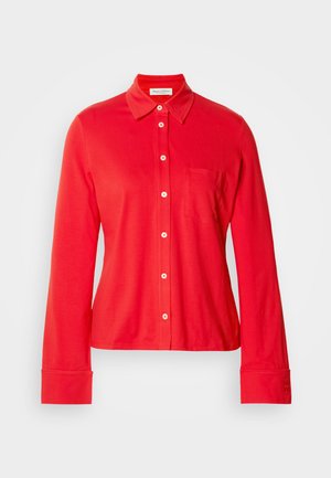 Rode blouse met lange mouwen, gemaakt van rekbaar materiaal, met een kraag, een enkele borstzak en witte knopen aan de voorkant en bij de manchetten.