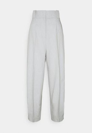 Pantalones de talle alto de color gris pálido, confeccionados a medida, con pliegues y cierre frontal con cremallera oculta.
