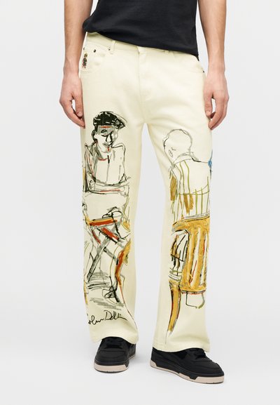 Τζιν παντελόνια σε κρεμ χρώμα με καλλιτεχνικά σχέδια σε μαύρο, πορτοκαλί και κίτρινο. Διαθέτουν υπογραφή στο τελείωμα και ραφές σε αντίθεση.