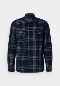 Marineblauwe overhemd met knoopsluiting en grijs geruit patroon, twee borstzakken met knoopflappen en een omgeslagen kraag.