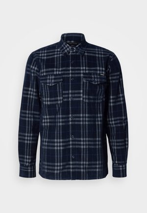 Camicia azzurra navy con pattern a quadri grigi, due tasche sul petto con patte a bottone e colletto pieghevole.