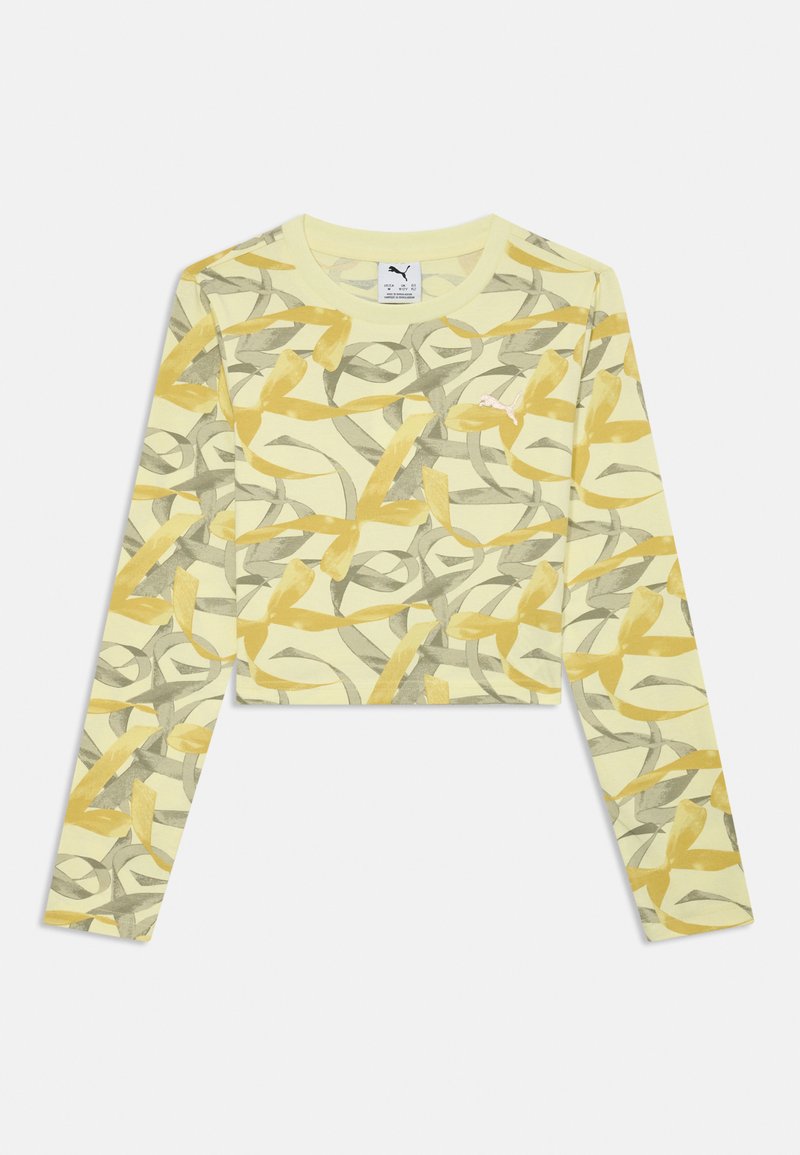 Žltý crop top s dlhým rukávom, ktorý má vírivý vzor v šedých a horčicových odtieňoch, s malým logom na hrudi. Mäkká textúra látky.