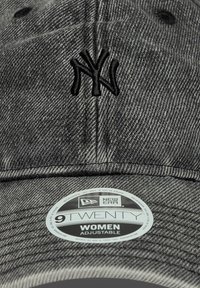 Cappellino da baseball in denim grigio con strap regolabile. Presenta un logo NY ricamato in nero, una corona arrotondata e un visiera piatta. Etichetta di branding circolare visibile.