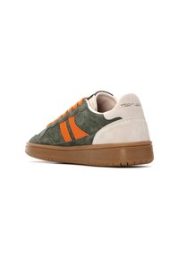 Sneaker verde in suede con righe arancioni e lacci, dettagli crema e una suola in gomma marrone textured. Logo evidente sul tallone.