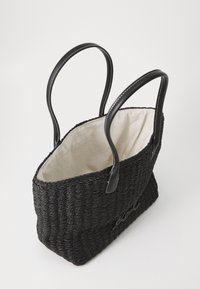 Black woven tote bag with smooth black leather handles and a beige fabric lining. Features a rectangular shape with an embroidered logo detail.