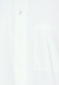 Ljusblå skjorta med knappar, i bomullstyg, slät textur, vänster bröstficka, fem vita knappar, standardkrage, utan synliga mönster.