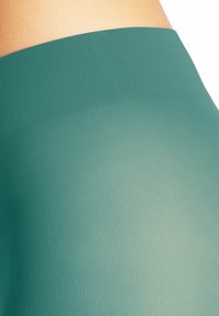 Leggings de sport teal avec une texture côtelée, une taille haute et un design sans couture qui améliore le confort et la flexibilité.