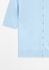 Lichtblauw kort mouw vestje met een rij kleine blauwe knopen aan de voorkant en geribbelde randen aan de mouwen en zoom.