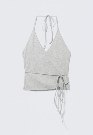 Haut cache-cœur sans manches gris clair avec un décolleté en V profond, des liens noués au cou style halter et des bandes sur les côtés pour enrouler autour de la taille.