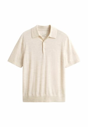 Polo beige en tissu texturé, avec un col classique, des manches courtes, une patte de boutonnage à trois boutons et un fini simple à l'ourlet.