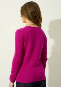 Pull fuchsia à manches longues avec un col rond, conçu près du corps, avec des poignets côtelés et une texture lisse, vu de dos.
