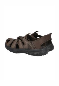 Sandalias marrones de dedo con parte superior de malla, correas elásticas y suela de goma negra duradera. Cuenta con un interior acolchado para mayor comodidad.