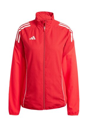 Rode sportjack gemaakt van lichtgewicht stof met een volledige rits. Heeft witte strepen op de schouders en zijkanten, en een hoge kraag.